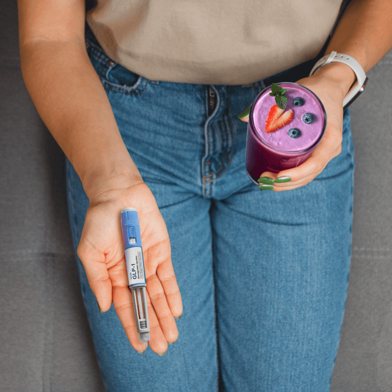 AuraStylo GLP-1 Nutrition Companion Classic: A person holding a smoothie and a pen, showcasing the product.